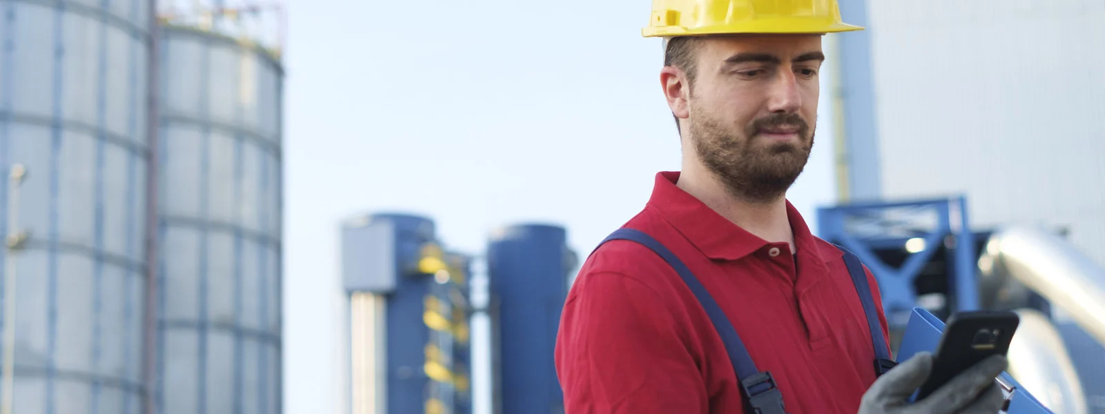 Handwerker am Werk hält Mobilgerät in der Hand.